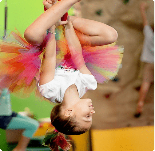 a young girl is doing a handstand on the floor.