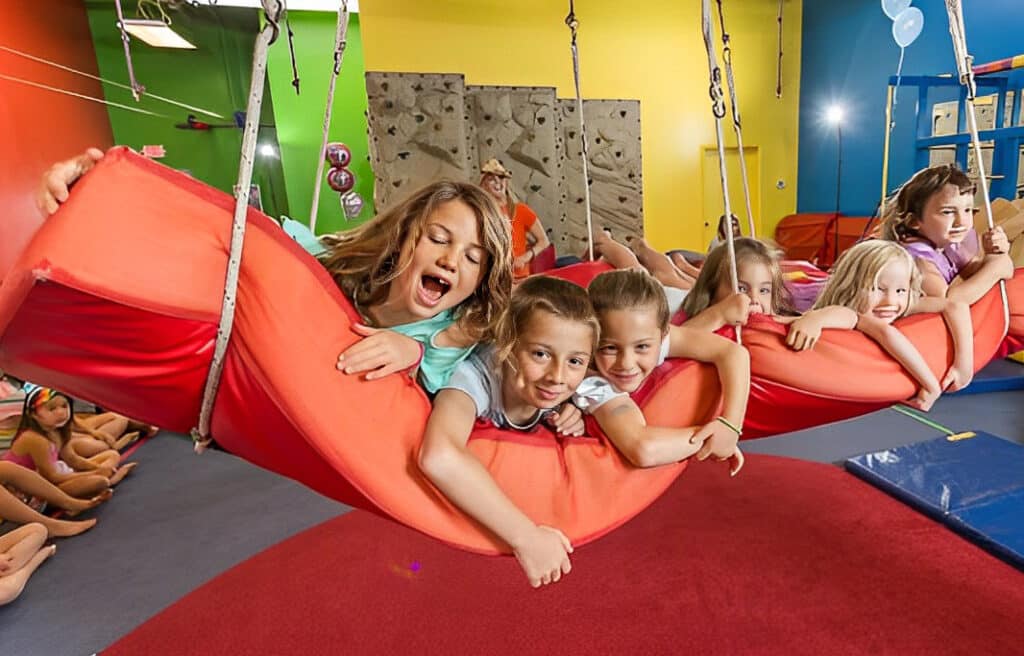 A group of children enjoying Child Fitness Classes in a hammock.