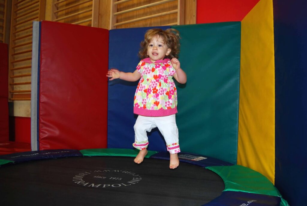 A child bouncing on a trampoline in a fitness class.